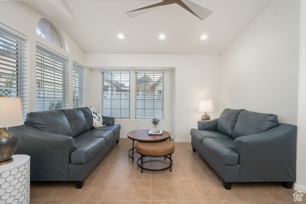 Living area with a ceiling fan, light tile patterned floors, baseboards, lofted ceiling, and recessed lighting