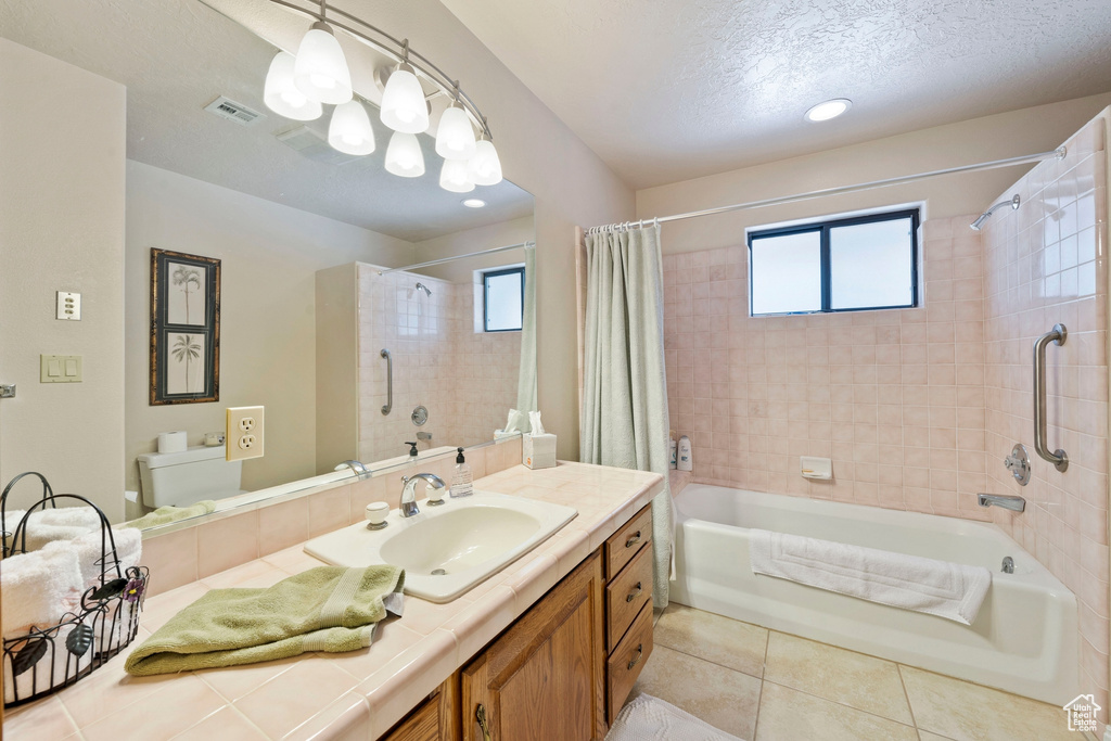 Bathroom with plenty of natural light, tile patterned floors, shower / bath combination with curtain, and visible vents