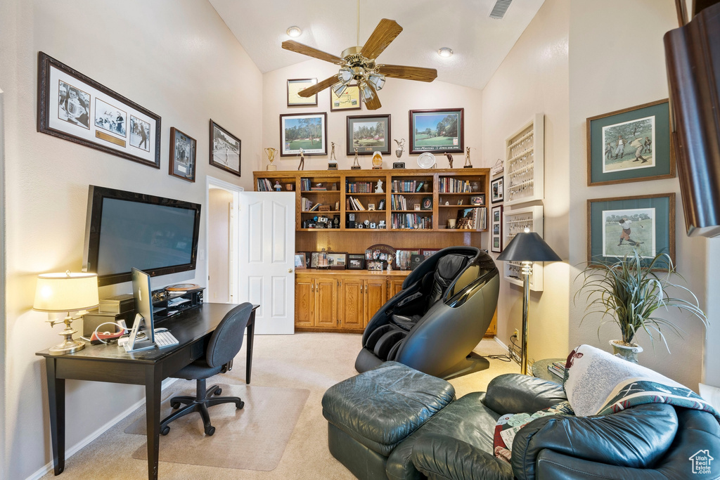Home office featuring light colored carpet, ceiling fan, lofted ceiling, and visible vents