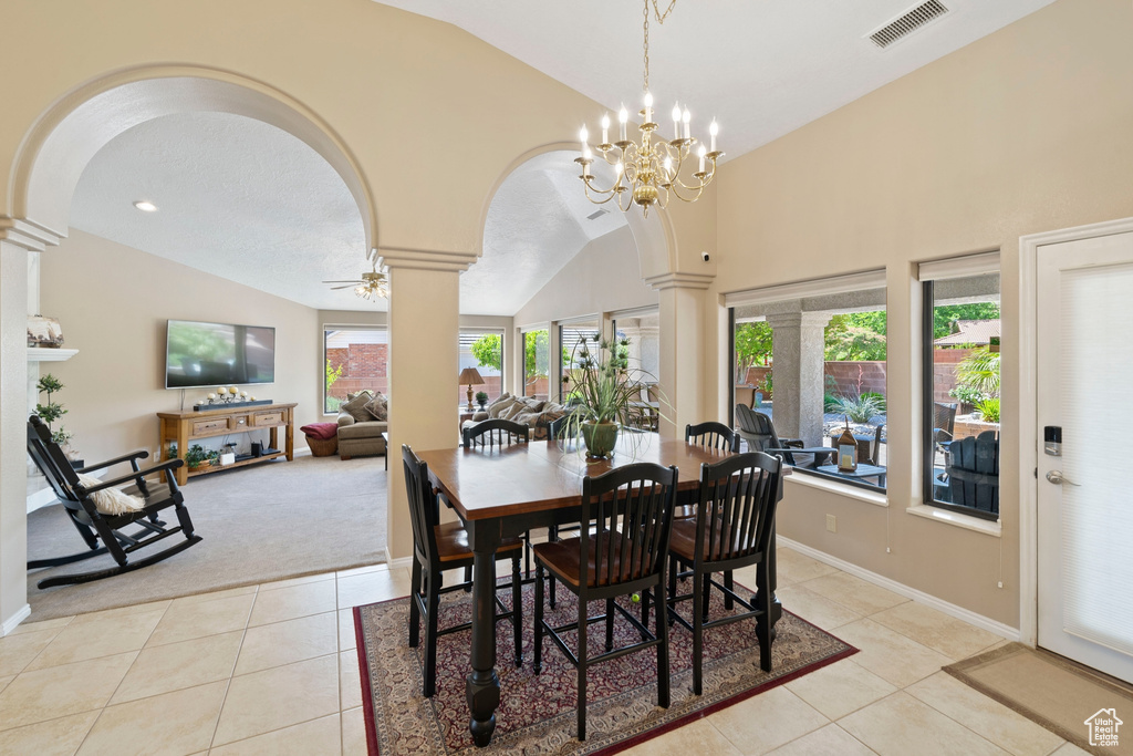 Dining space with visible vents, arched walkways, lofted ceiling, ornate columns, and light tile patterned flooring