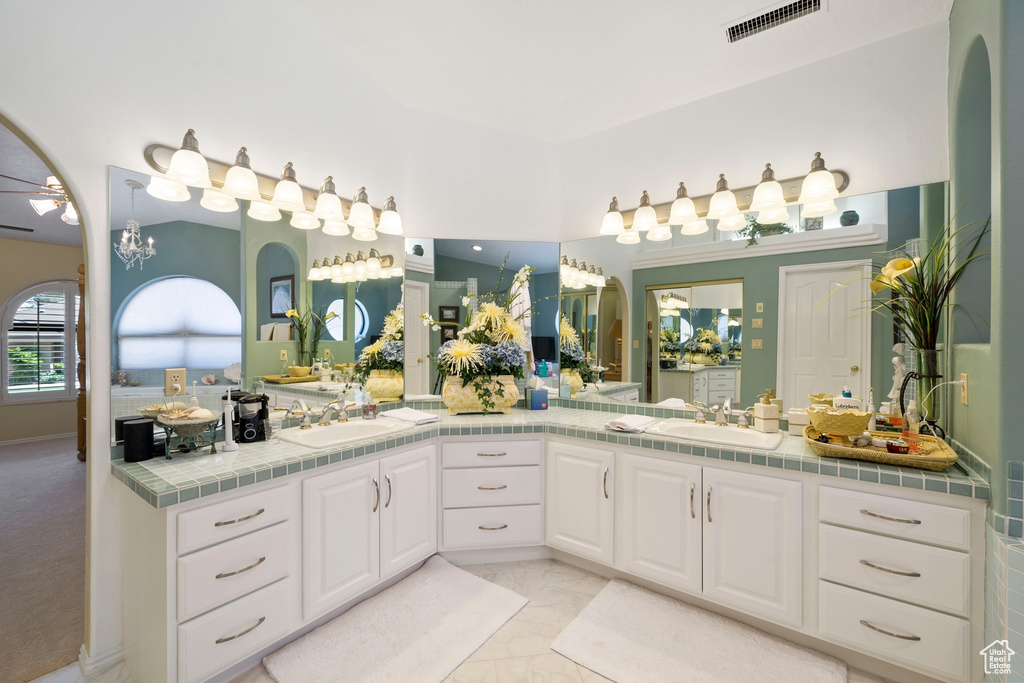 Full bathroom with visible vents, a sink, marble finish floor, and double vanity