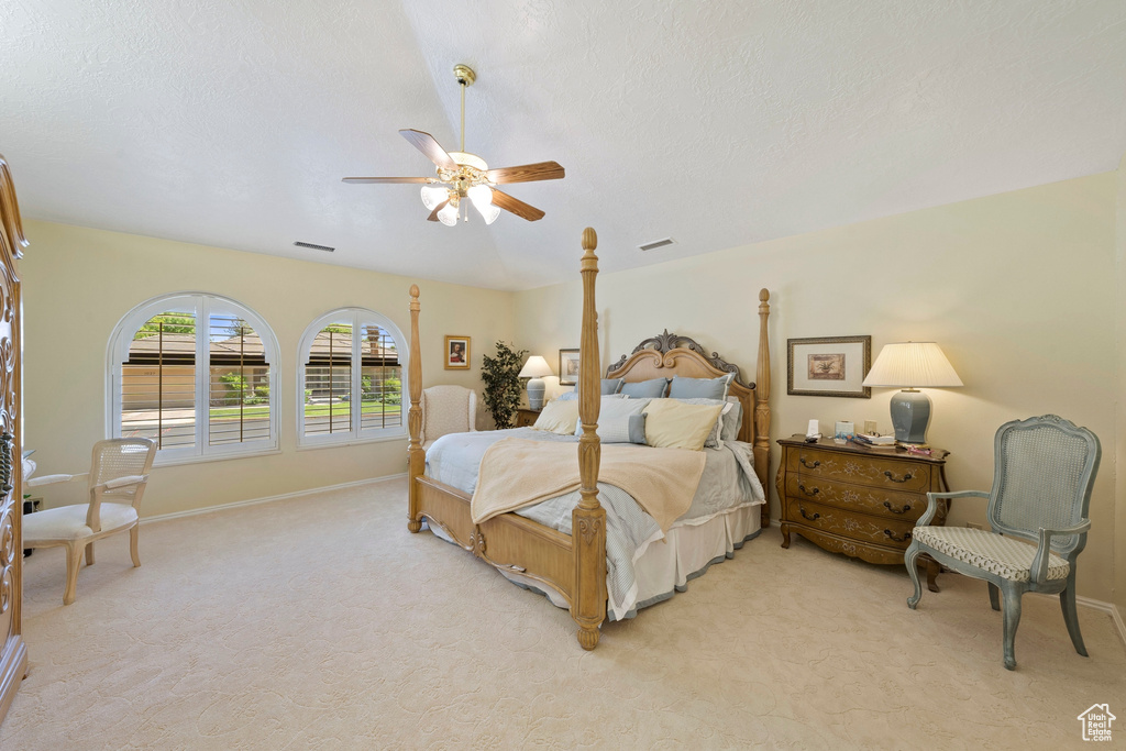 Bedroom featuring ceiling fan, visible vents, light carpet, and baseboards