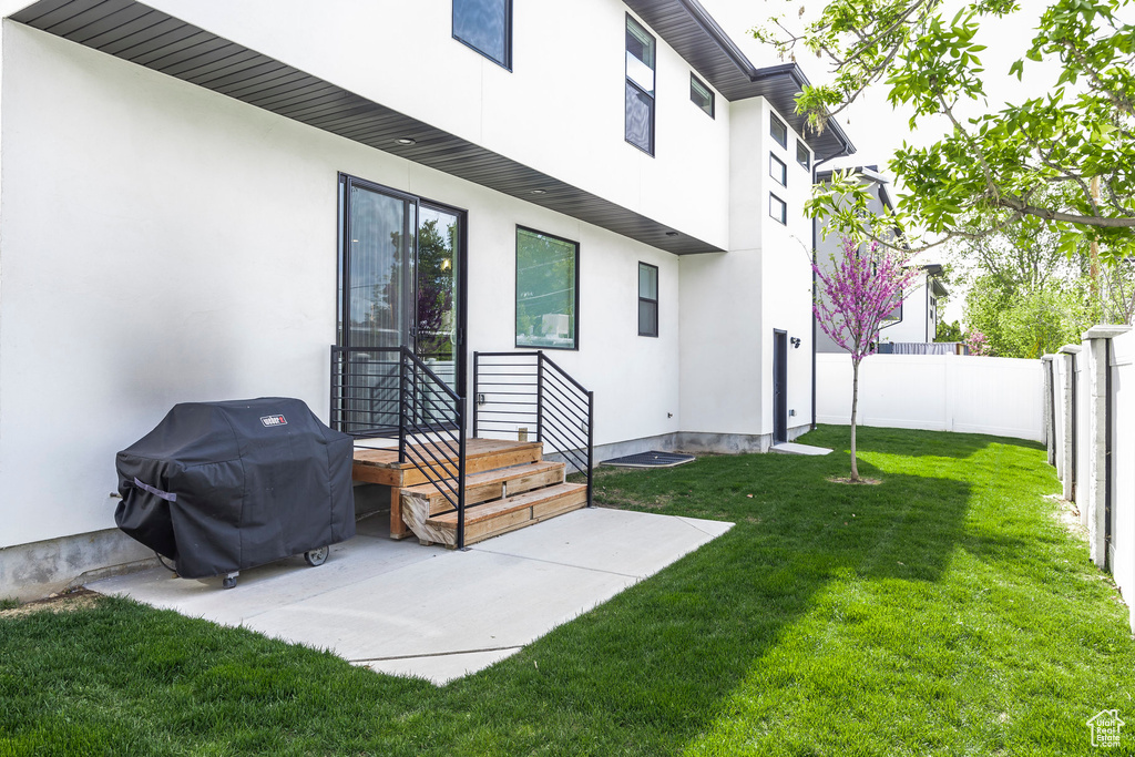 Rear view of property featuring a fenced backyard, stucco siding, and a lawn