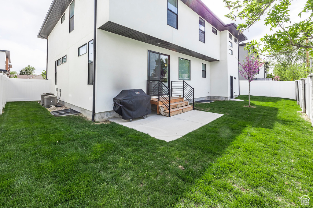 Back of house with a lawn, a fenced backyard, and stucco siding