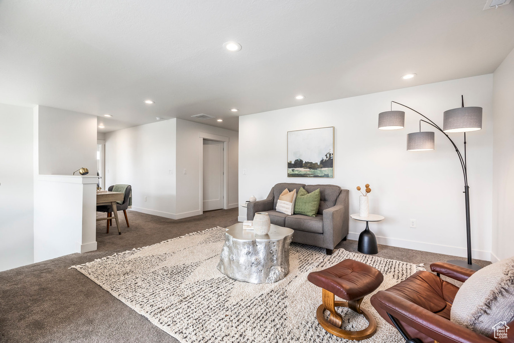 Carpeted living room with recessed lighting and baseboards