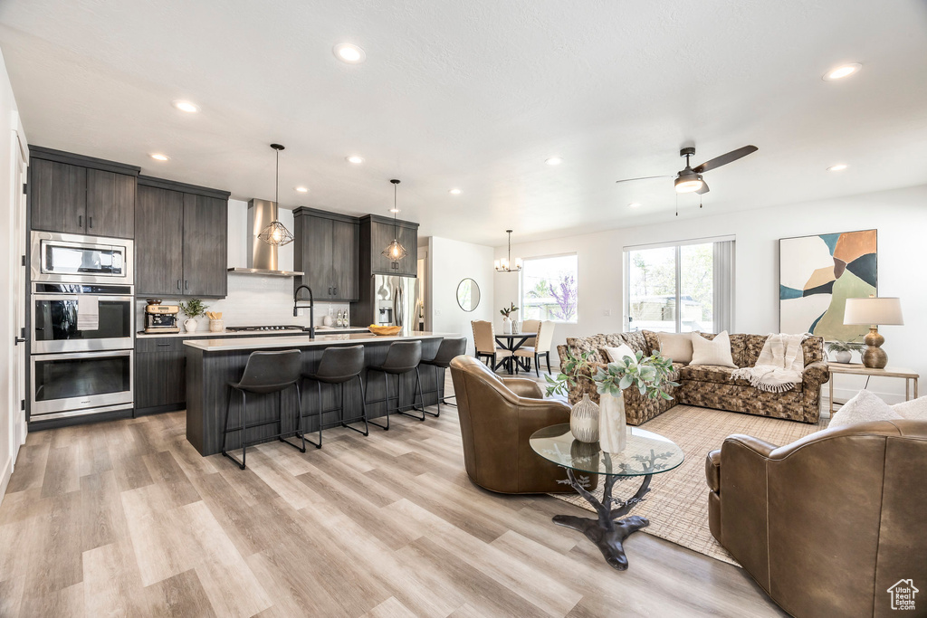 Living area with recessed lighting, ceiling fan, and light wood-style floors