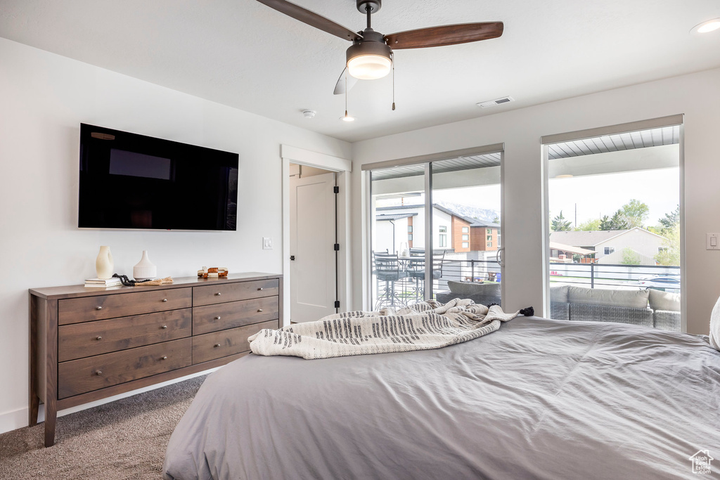 Carpeted bedroom with visible vents, a ceiling fan, and access to exterior