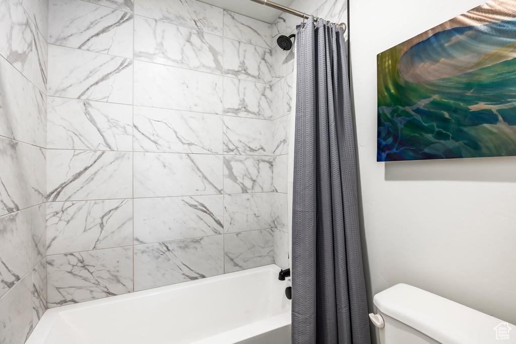 Bathroom featuring shower / bath combo and toilet