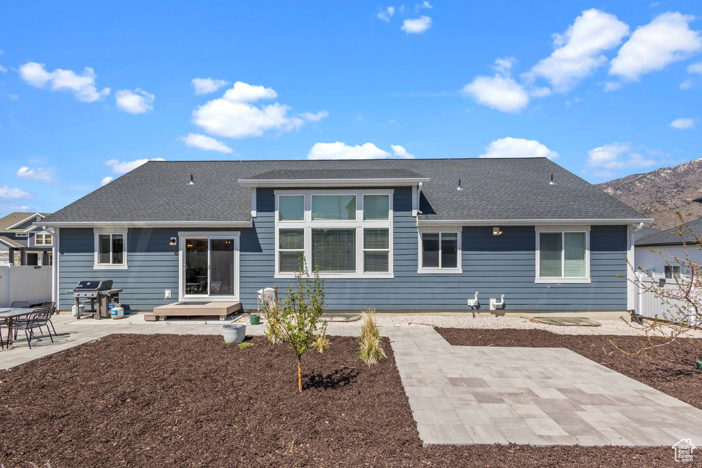 Back of property with roof with shingles, fence, and a patio