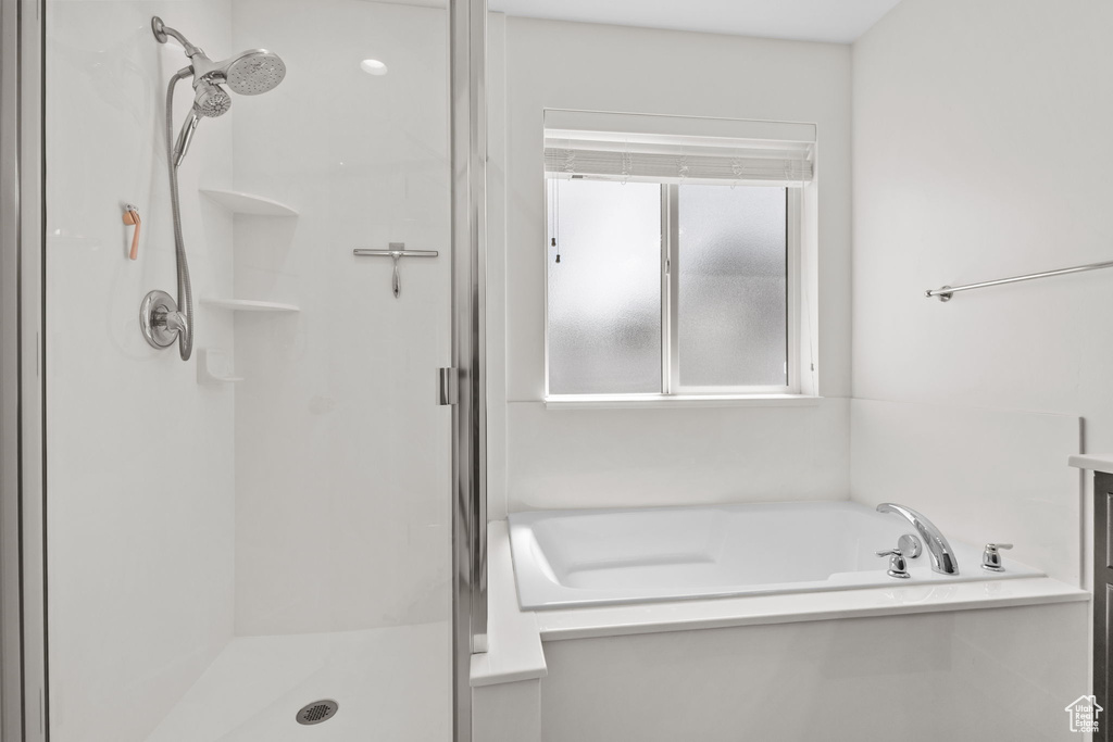 Bathroom featuring a stall shower and a bath