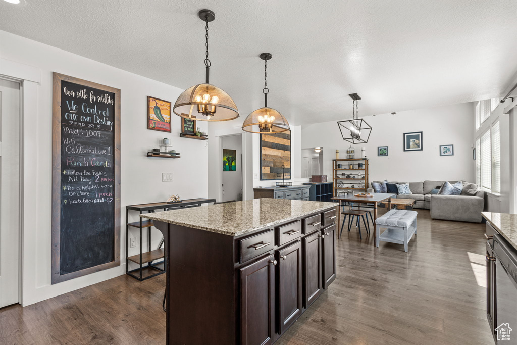 Kitchen featuring an inviting chandelier, dark wood-style flooring, dark brown cabinetry, and hanging light fixtures