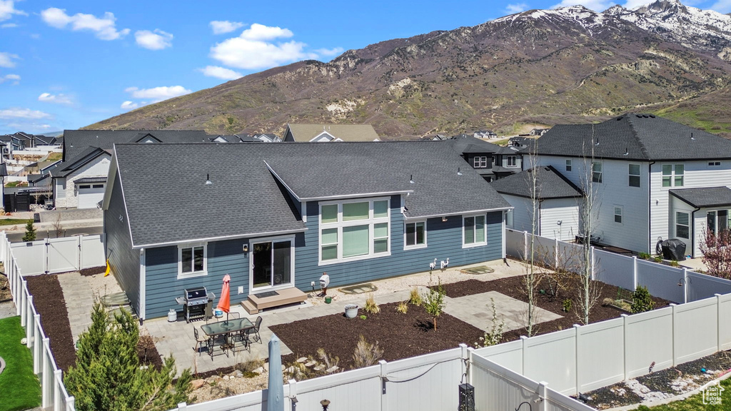 Back of property with a residential view, a shingled roof, a fenced backyard, a gate, and a patio
