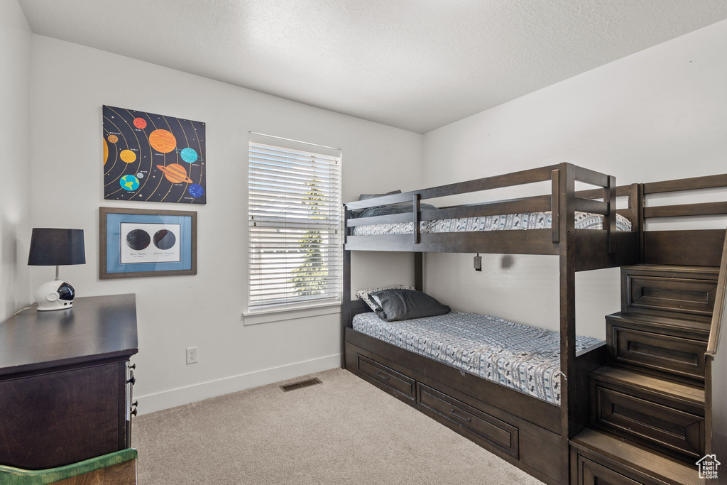 Bedroom with carpet floors, baseboards, and visible vents