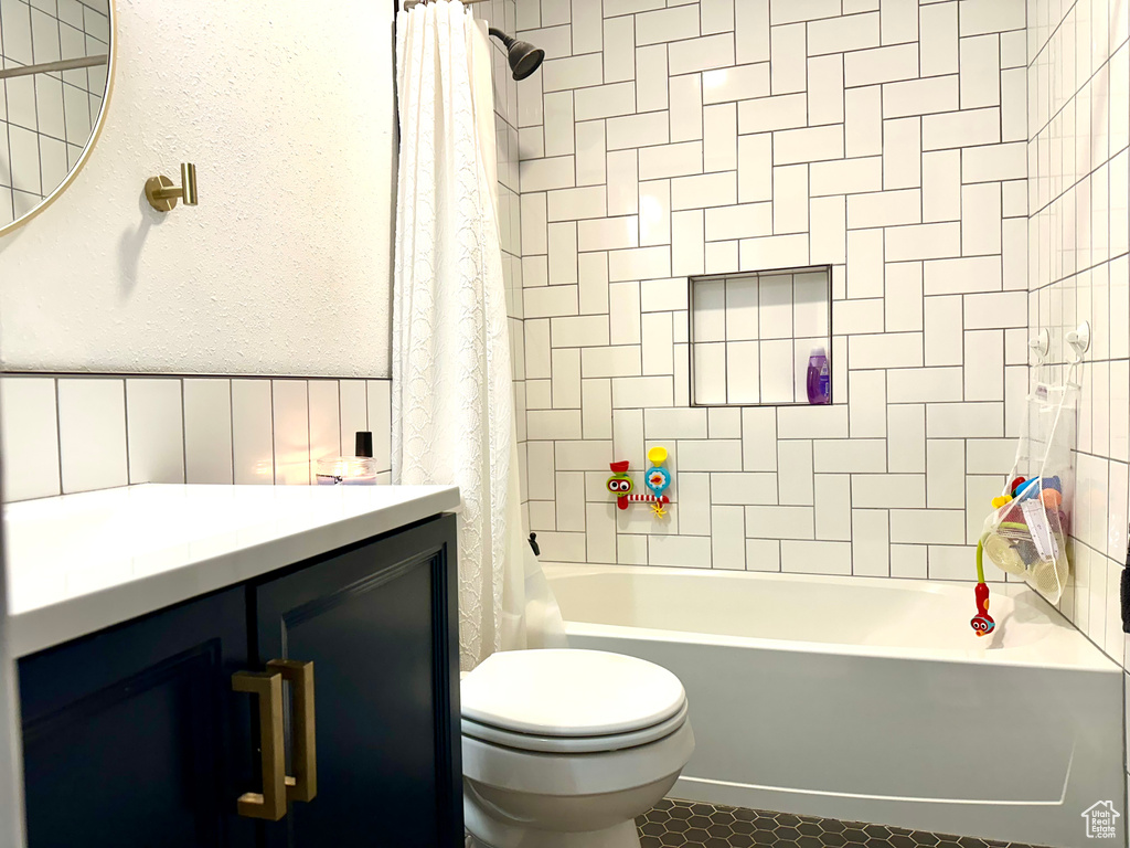 Full bathroom with vanity, toilet, and shower / bath combination with curtain