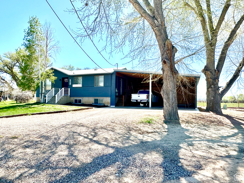 Single story home with an attached carport and gravel driveway