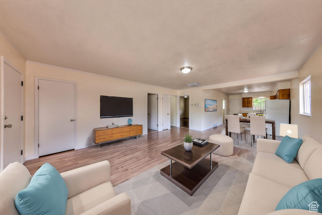 Living area with light wood-style flooring and visible vents