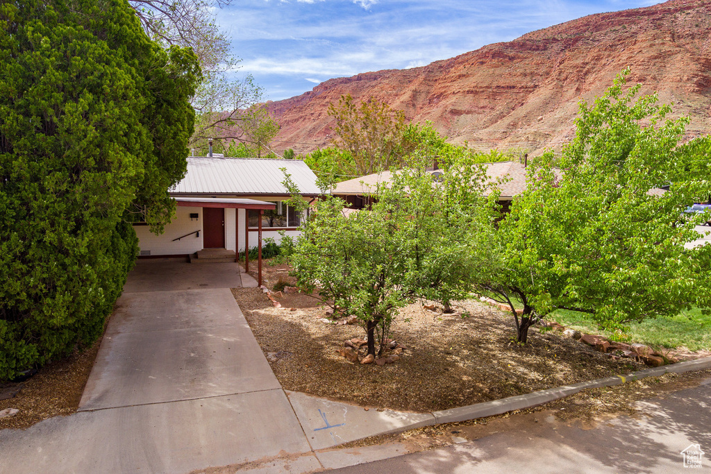 View of front of property with concrete driveway, metal roof, and a mountain view