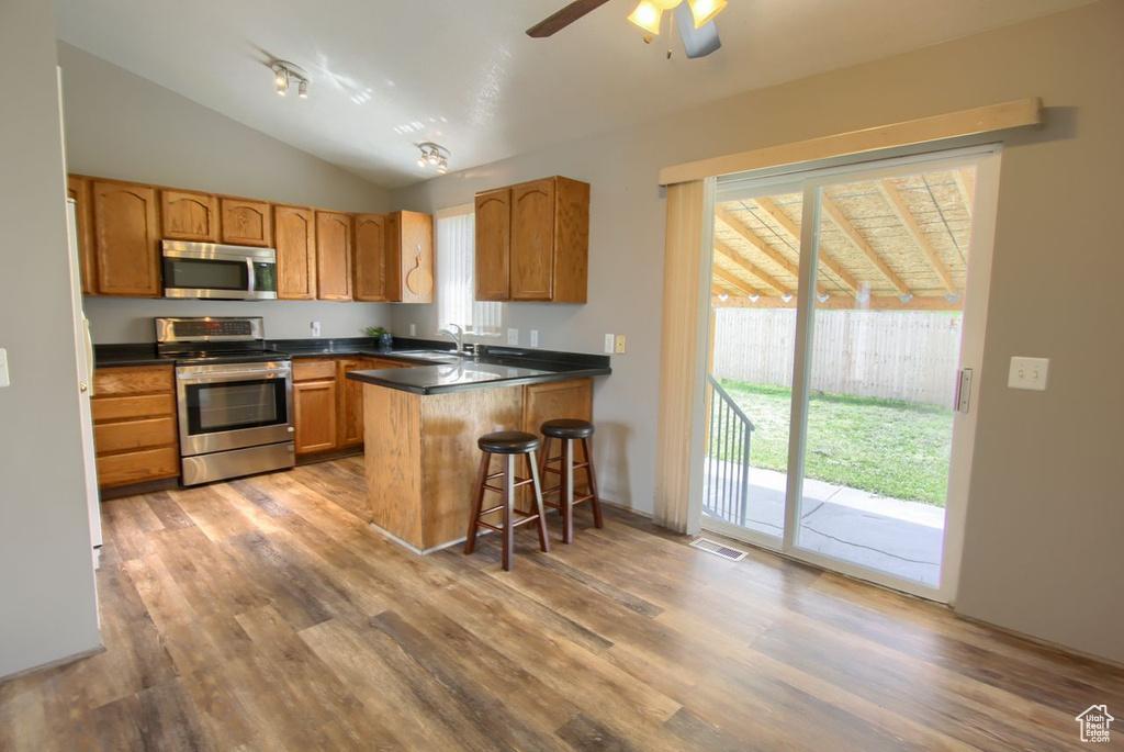 Kitchen with visible vents, plenty of natural light, wood finished floors, and stainless steel appliances