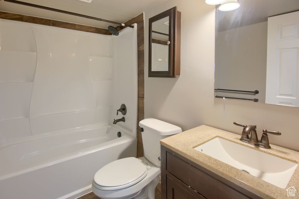 Bathroom with vanity, shower / bath combination, and toilet