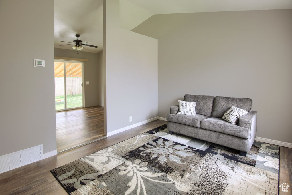 Living room with ceiling fan, lofted ceiling, wood finished floors, and visible vents
