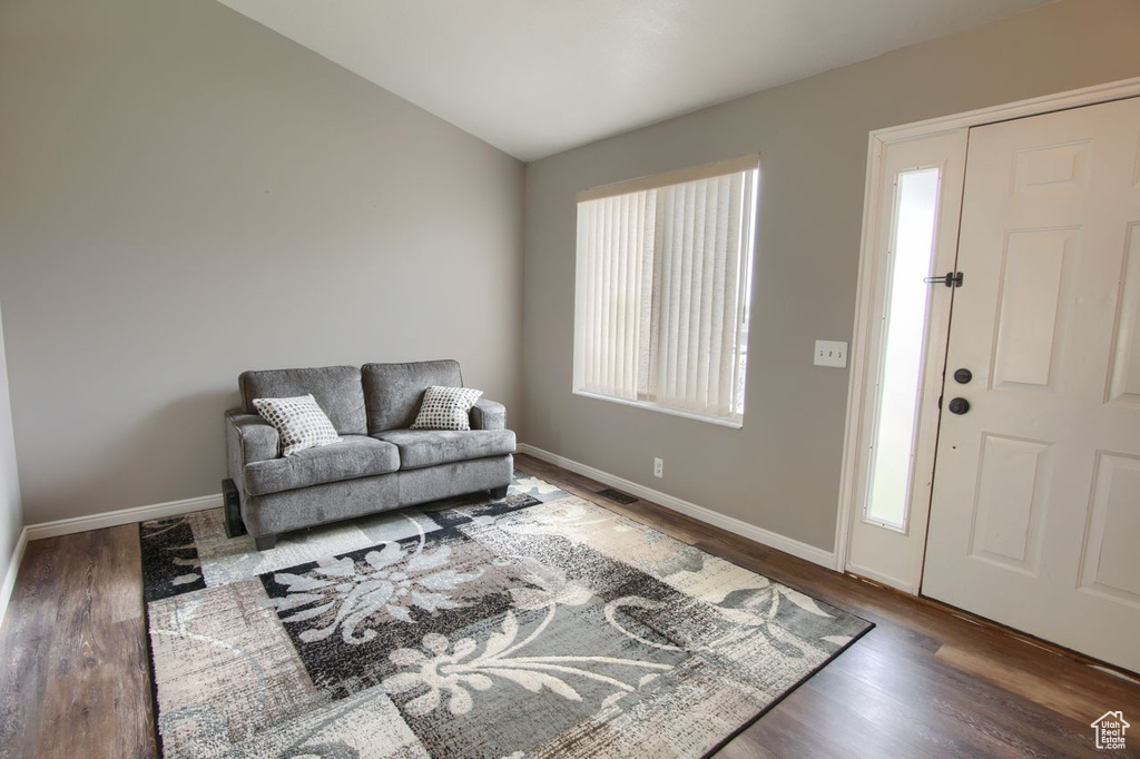 Living area with baseboards, a wealth of natural light, and wood finished floors