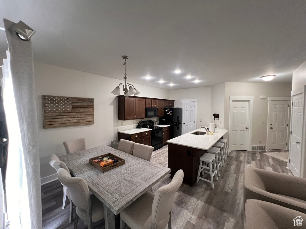 Dining room featuring visible vents, baseboards, a chandelier, and dark wood-style floors