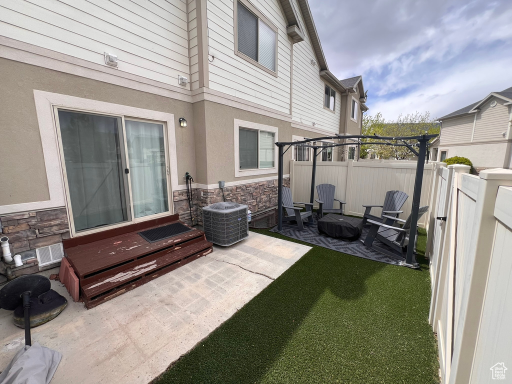 View of patio with central air condition unit and fence