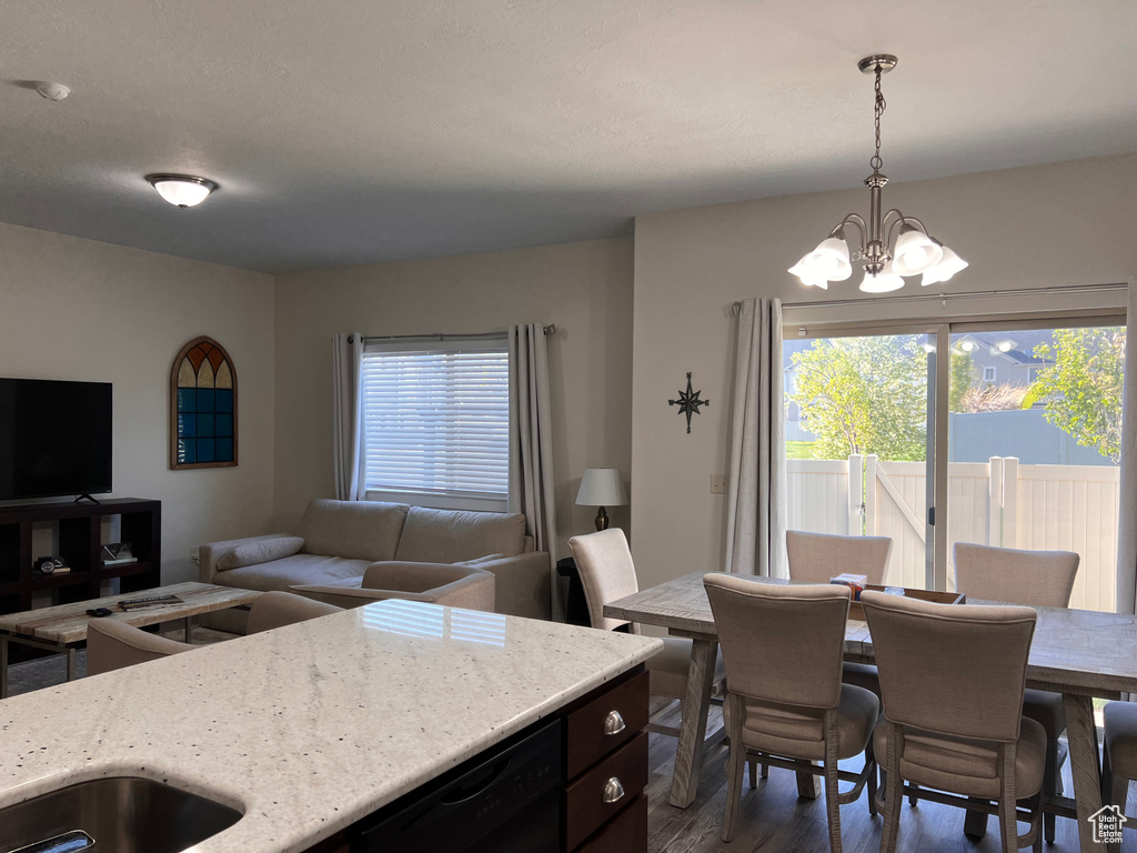 Dining area featuring an inviting chandelier and dark wood-type flooring