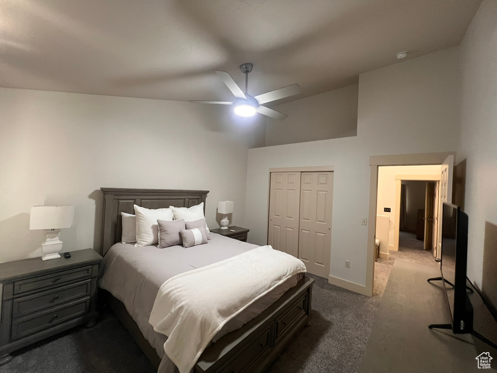 Bedroom featuring a closet, dark colored carpet, baseboards, high vaulted ceiling, and a ceiling fan