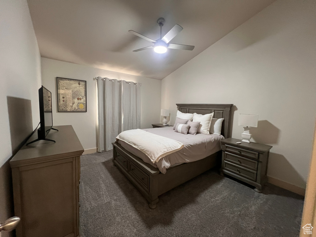 Bedroom featuring dark carpet, a ceiling fan, baseboards, and lofted ceiling