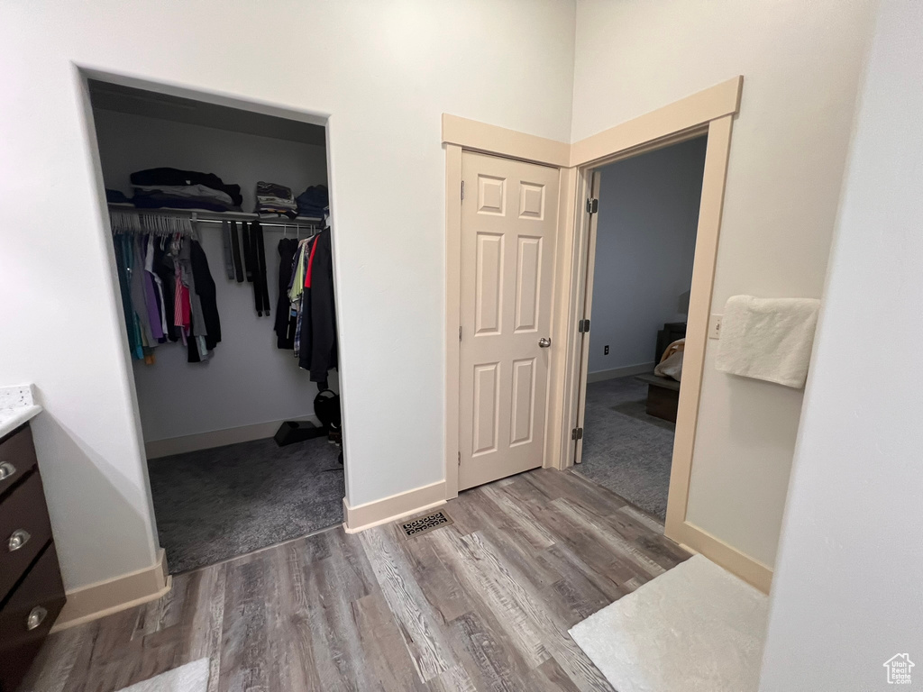 Bathroom with baseboards, visible vents, wood finished floors, and vanity