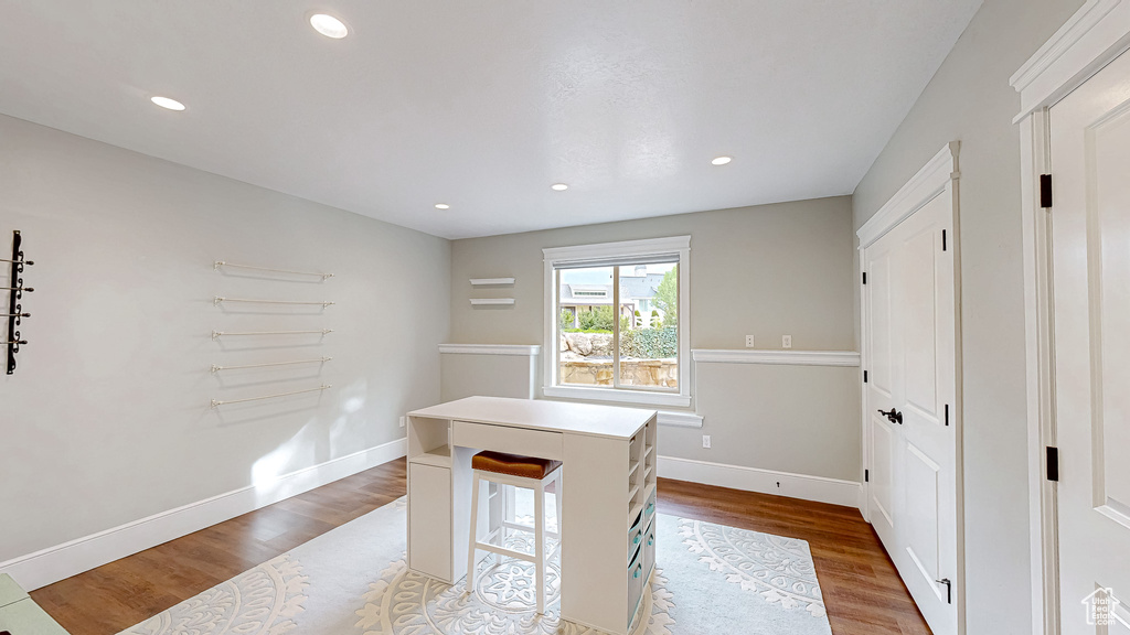 Unfurnished office with recessed lighting, baseboards, and wood finished floors