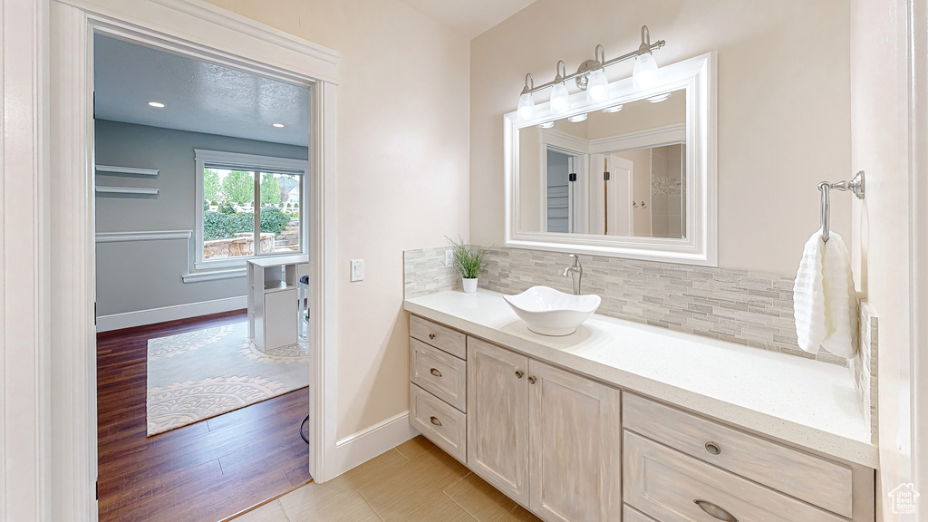Bathroom featuring baseboards, decorative backsplash, and vanity