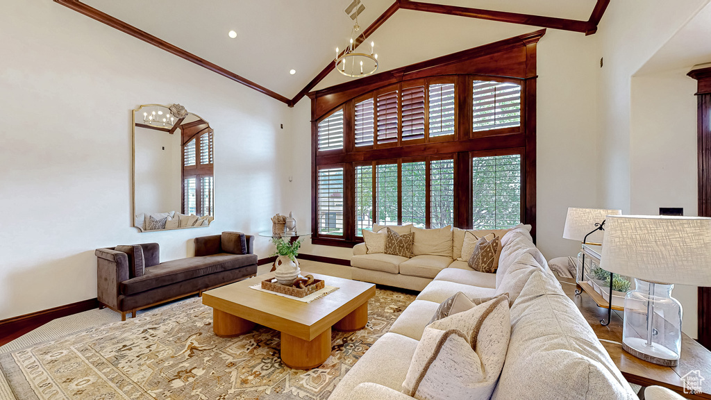 Living area featuring crown molding, baseboards, high vaulted ceiling, recessed lighting, and a chandelier