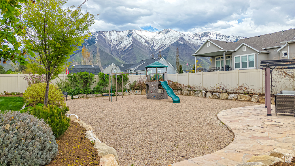 View of play area with fence and a mountain view