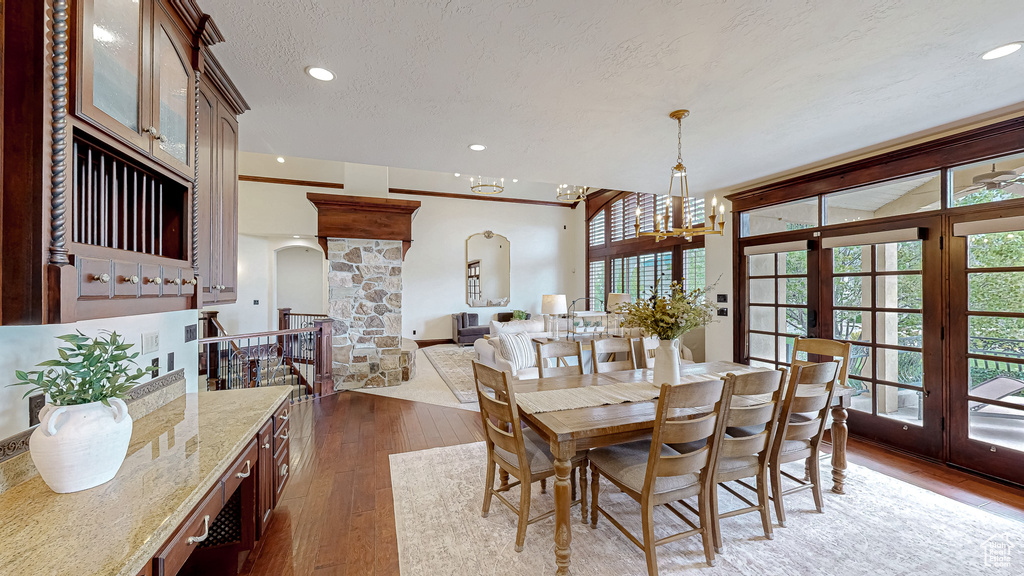 Dining space with arched walkways, plenty of natural light, french doors, and dark wood-style floors