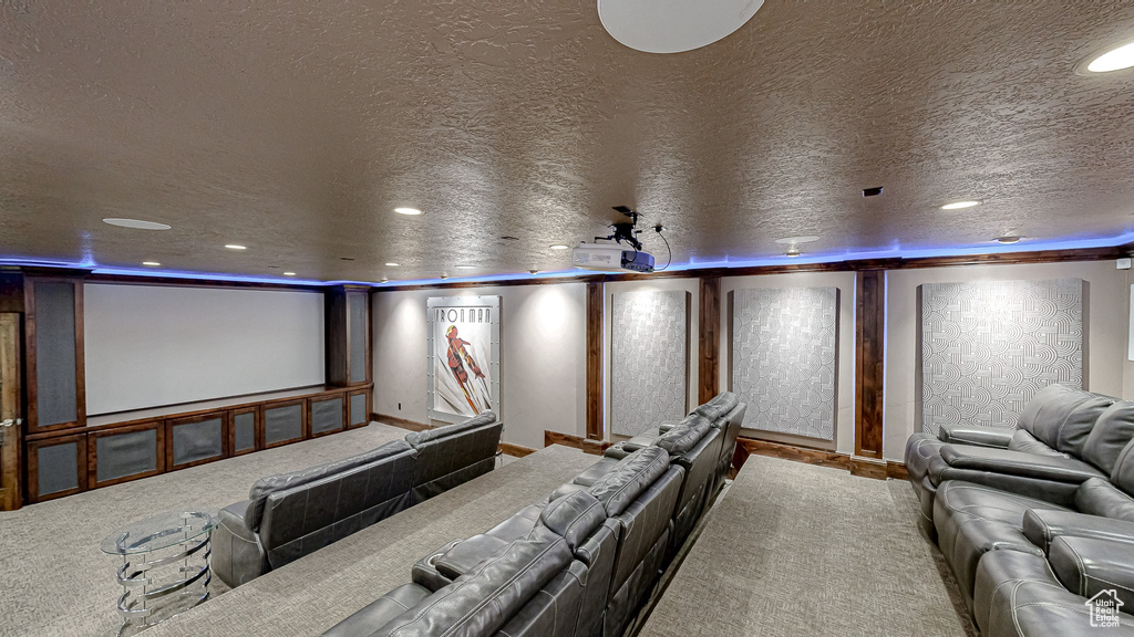 Carpeted home theater room with recessed lighting, a textured ceiling, and baseboards