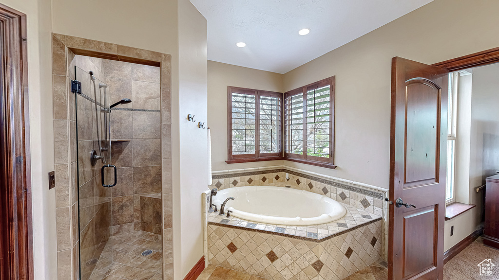 Bathroom with a garden tub, recessed lighting, and a shower stall