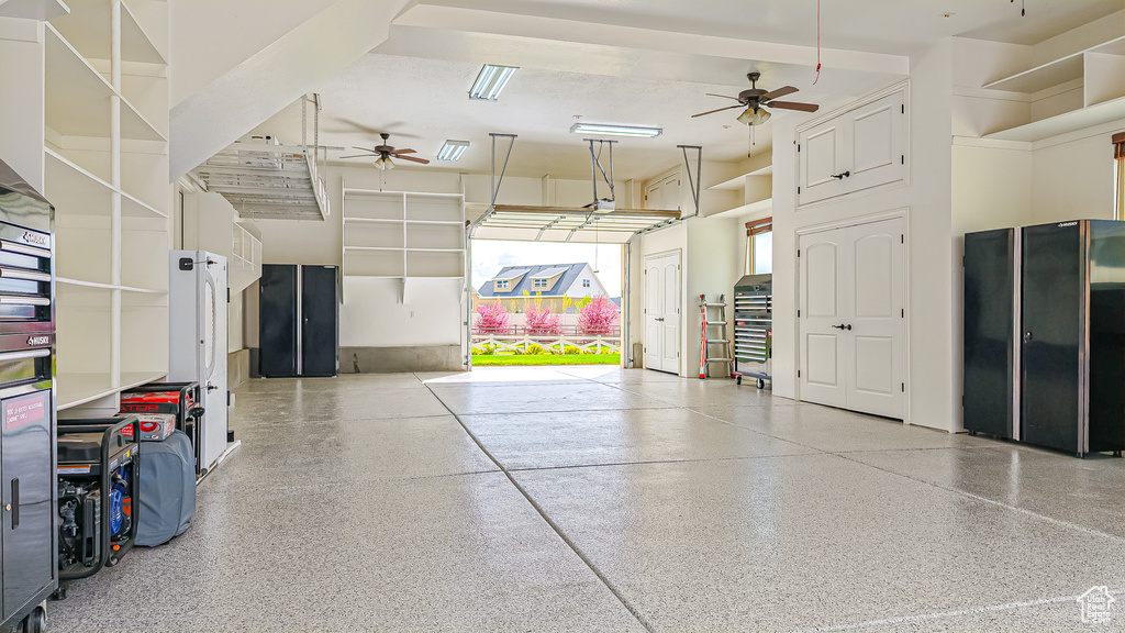 Garage featuring ceiling fan and freestanding refrigerator