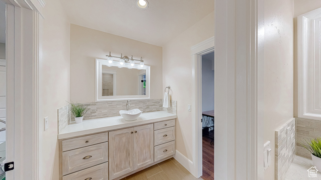 Bathroom with vanity, decorative backsplash, and wood finished floors