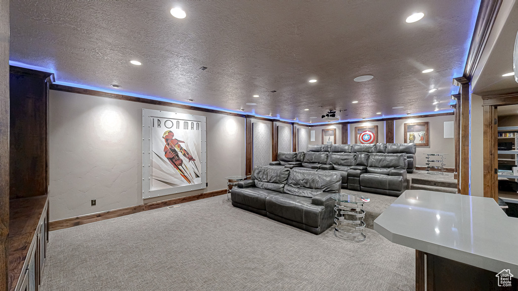 Home theater room with baseboards, carpet, recessed lighting, and a textured ceiling