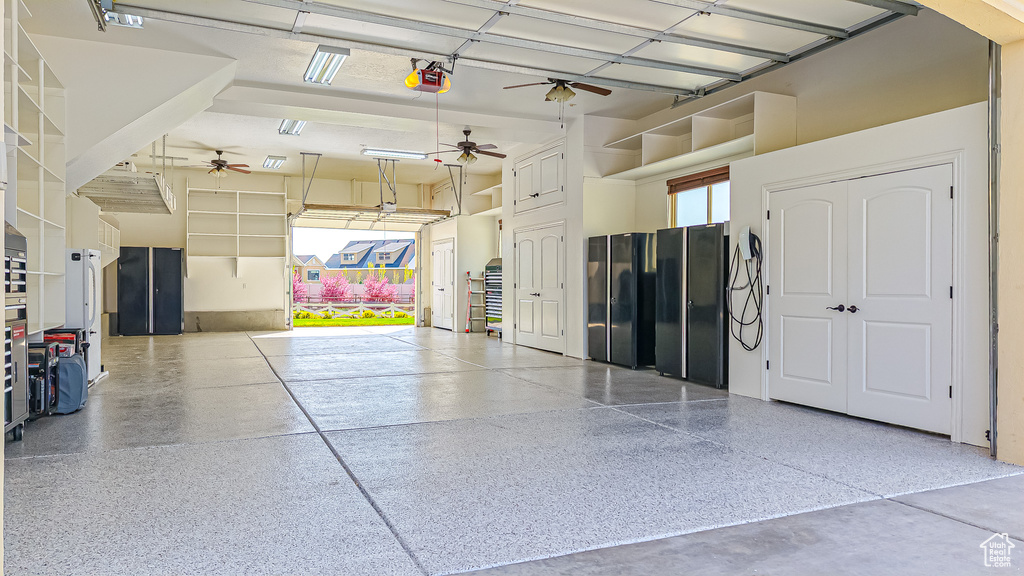 Garage featuring freestanding refrigerator, a ceiling fan, and a garage door opener
