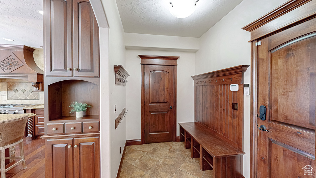 Mudroom featuring baseboards and a textured ceiling