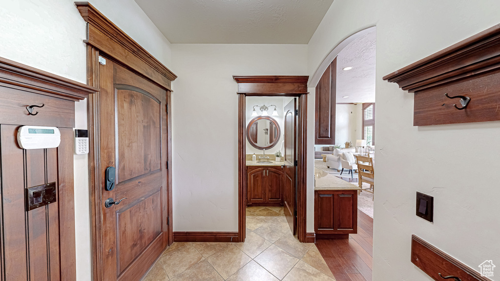 Interior space featuring light tile patterned floors, arched walkways, and baseboards