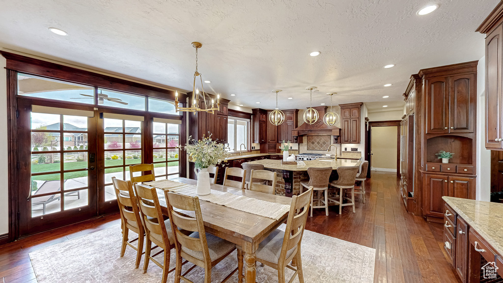 Dining room featuring wood-type flooring, a textured ceiling, french doors, ceiling fan with notable chandelier, and recessed lighting