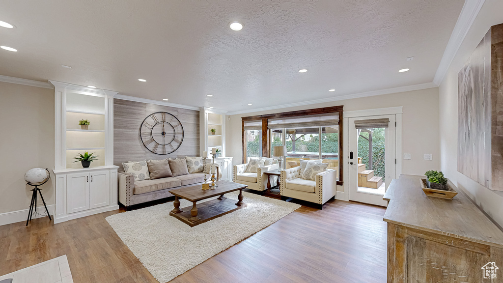 Living room with light wood-type flooring and recessed lighting