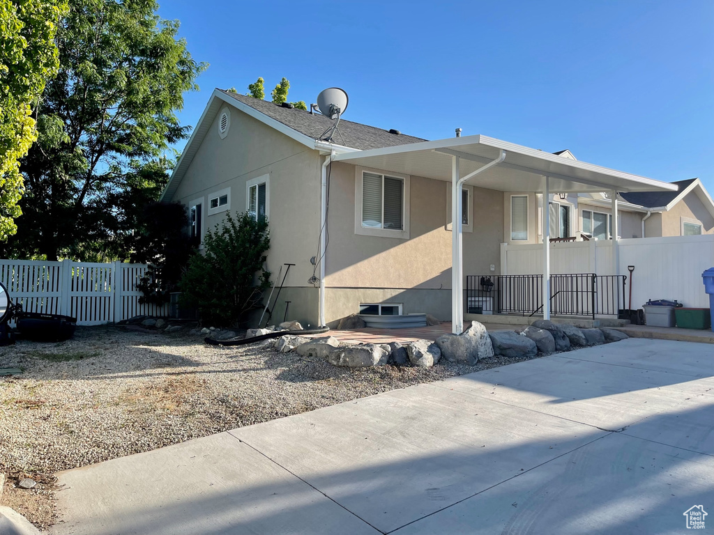 Exterior space featuring covered porch, fence, and stucco siding