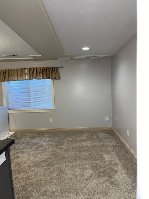 Spare room featuring carpet floors, baseboards, and visible vents