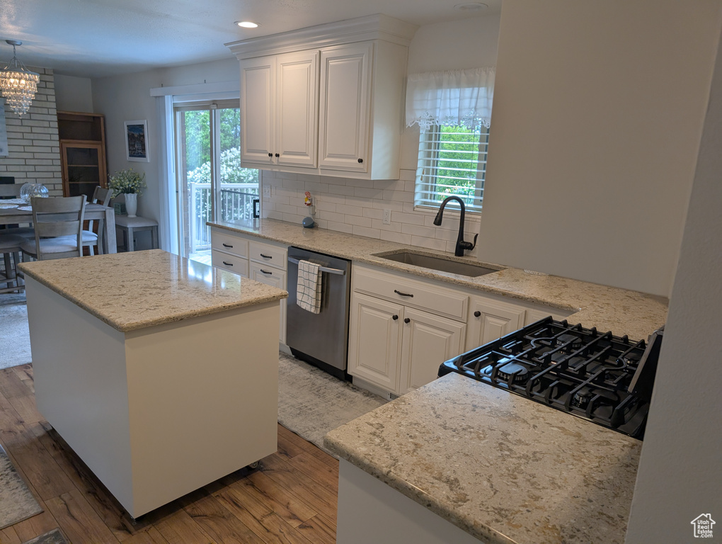 Kitchen with dishwasher, a sink, range, light wood-style flooring, and healthy amount of natural light