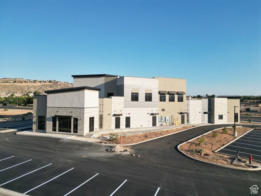 View of building exterior featuring uncovered parking